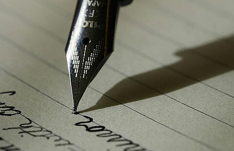 Photo d'un stylo à plume en train d'écrire un texte